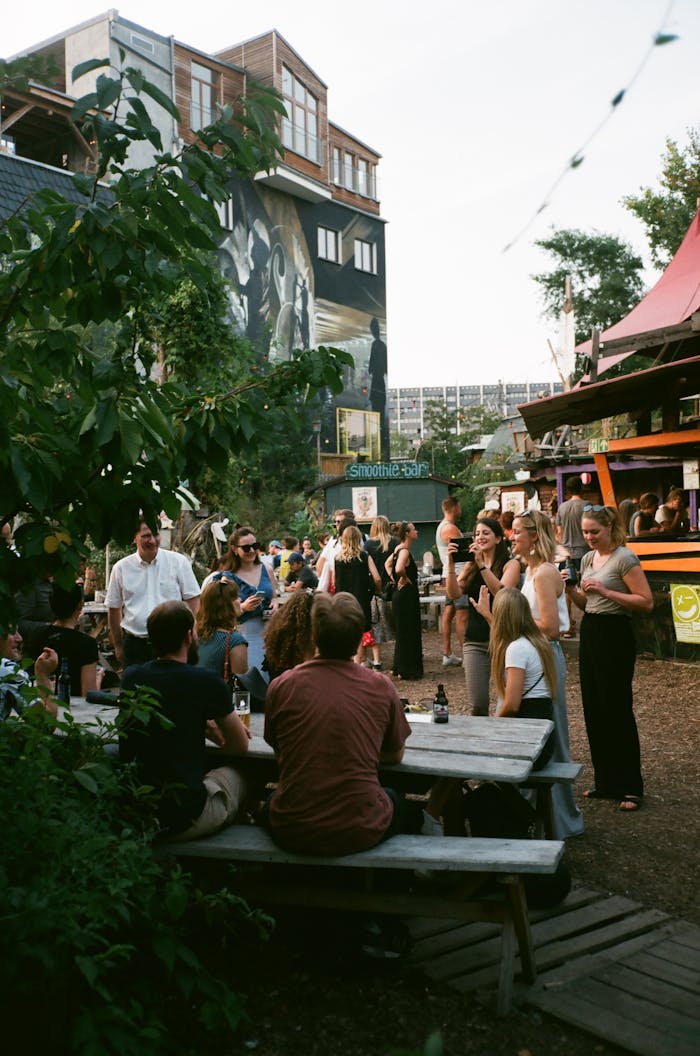 portfolio-02 Lively outdoor gathering at a trendy urban spot with people socializing and enjoying drinks.